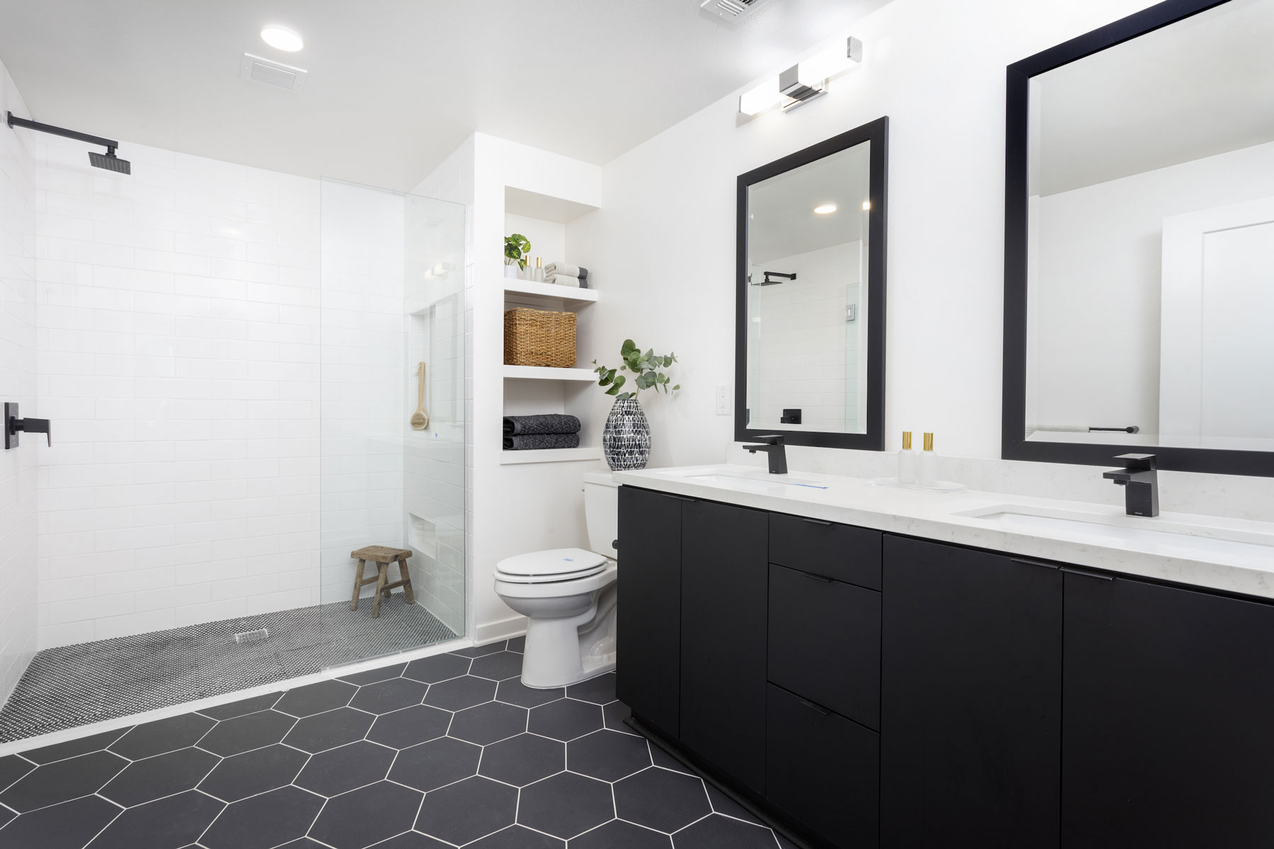 large apartment bathroom double vanity black cabinets hex tile broadstone atlas